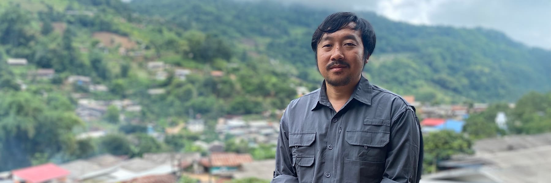 Student Khong Meng Her, overlooking town and lush forest in Thailand.