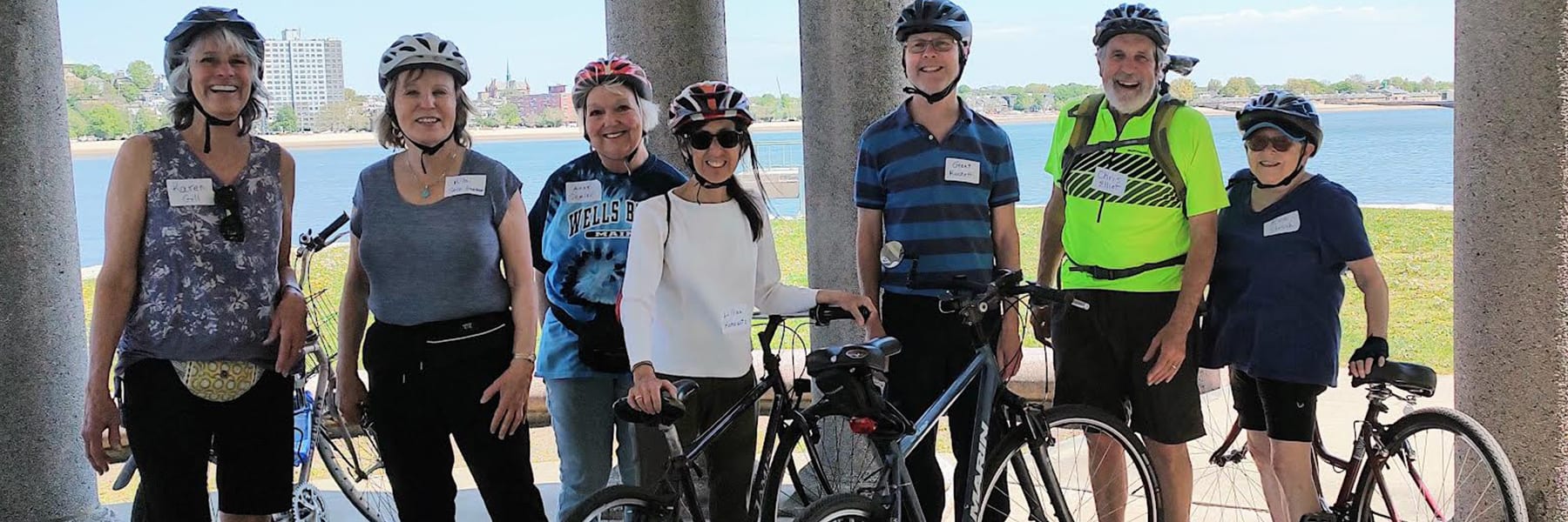 Older adults pose with bikes on the Harborwalk.