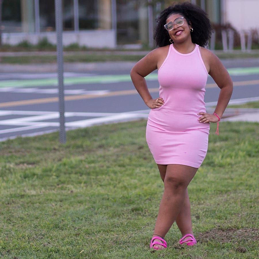 Student poses in pink dress at Campus Center.