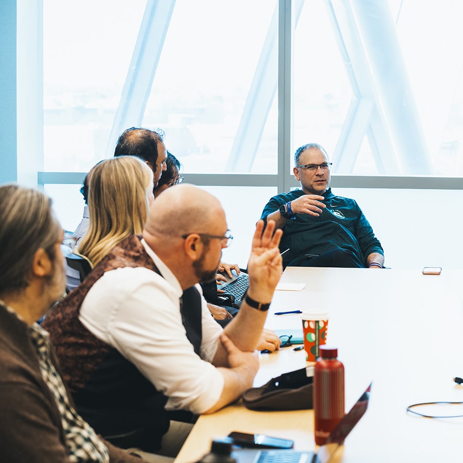 Faculty members talk during department chair meeting.