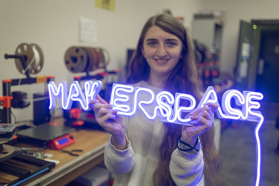 UMass Boston Student Holding MakerSpace Sign