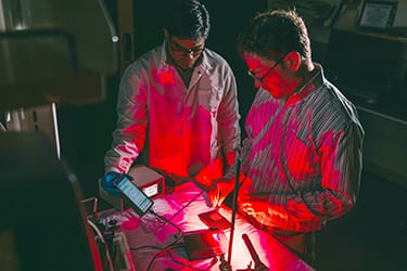 Jonathan Celli in labcoat working on research