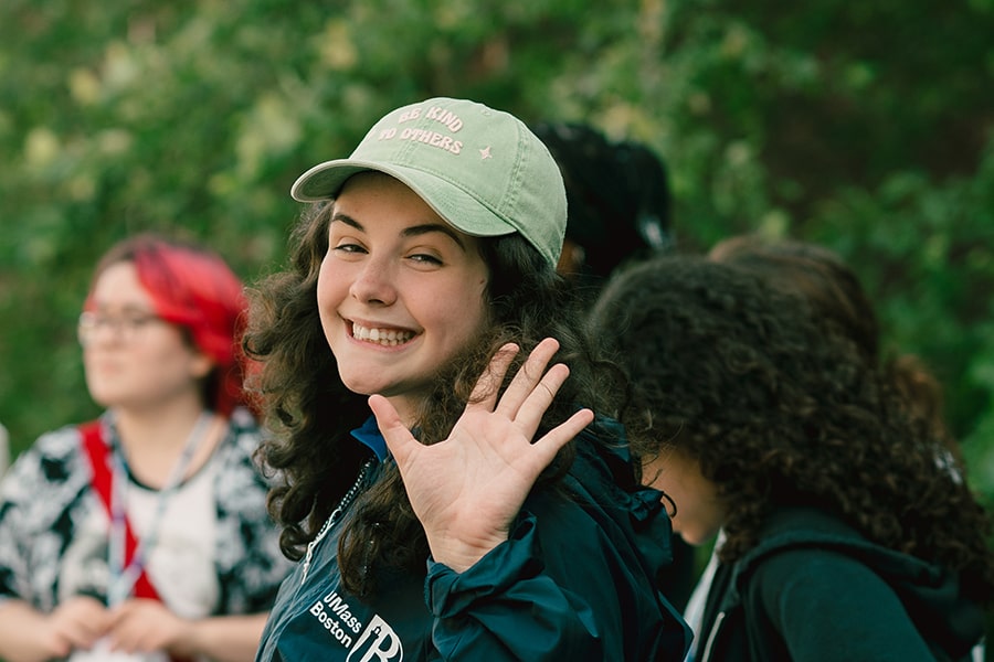 female student with cap looks back and waves