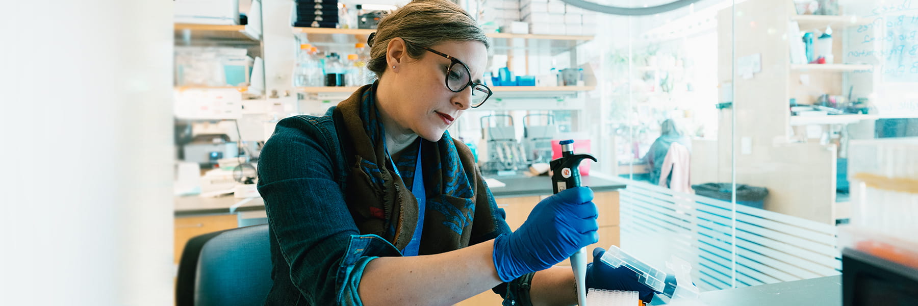 Researcher holds tool in lab at UMass Boston.