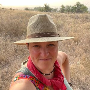 woman wearing a straw fedora and red handkerchief around her neck